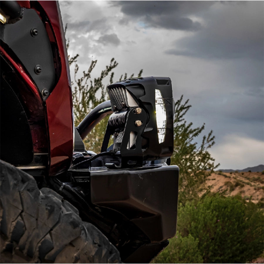 Off-road vehicle with additional lighting setup against a natural landscape