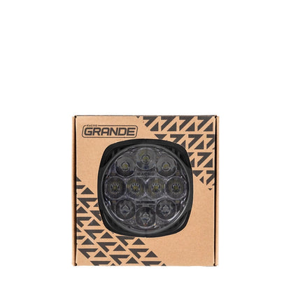 Cardboard packaging with a geometric pattern and 'Grande' branding, featuring a black circular product.