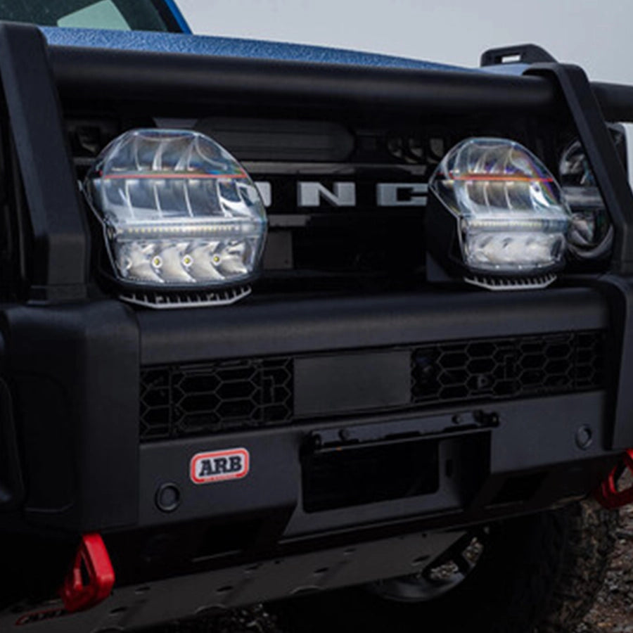 Close-up of a vehicle's front bumper with 'ARB' logo, on a blurred background.