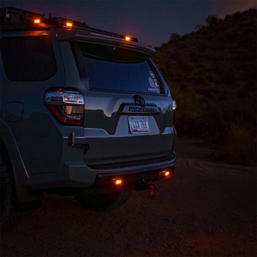 Toyota SUV with additional lights on at night in a desert setting