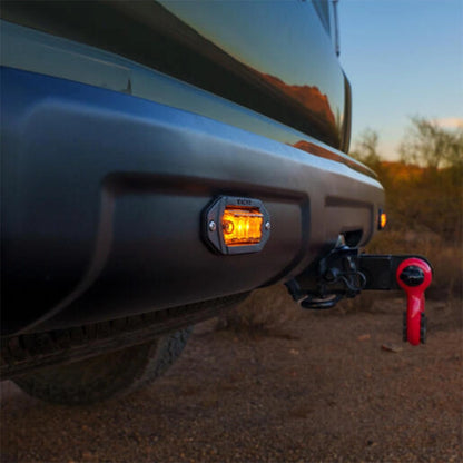 Close-up of a vehicle's fog light with a desert landscape in the background