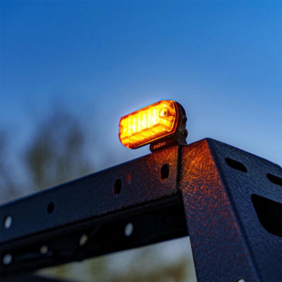 Amber LED light on a metal bracket against a blue sky
