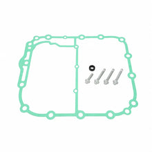 A light green engine gasket set with three silver bolts, a black rubber washer, and a small white paper clip on a solid white background.